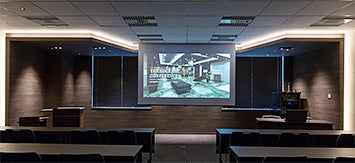 ステージを模したプレゼンテーションスペースは、下がり天井と間接照明の作用で講師や発表者をよりスタイリッシュに魅せる設計